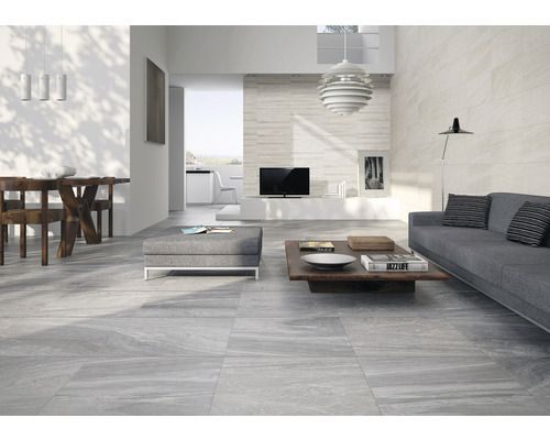 Moderne woonkamer met grijze vloertegels, bank en eettafel.