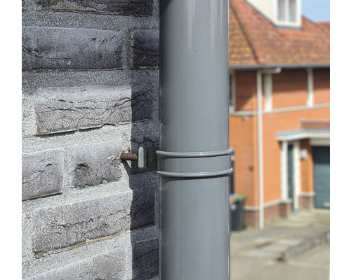Regenpijp aan een huismuur met bevestiging