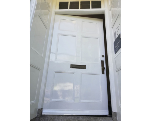 Gedeeltelijk geopende voordeur met brievenbus en fittingen