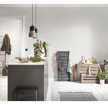 Lichte keuken met kookeiland, kruk, krijtbord en houten kisten als decoratie.