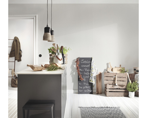 Lichte keuken met kookeiland, kruk, krijtbord en houten kisten als decoratie.