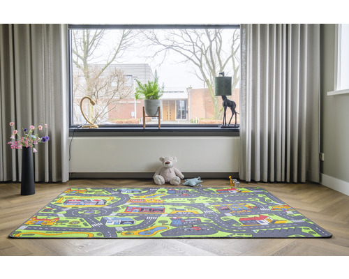 Speelkamer met een tapijt met stratenpatroon, teddybeer en speelgoed