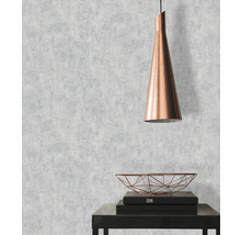 Woonkamer met behang met patroon, hanglamp en decoratieve schaal op een tafel