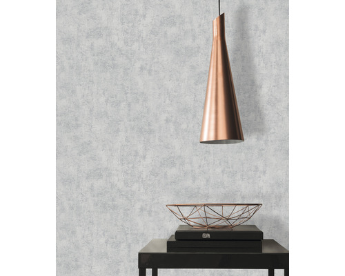 Woonkamer met behang met patroon, hanglamp en decoratieve schaal op een tafel