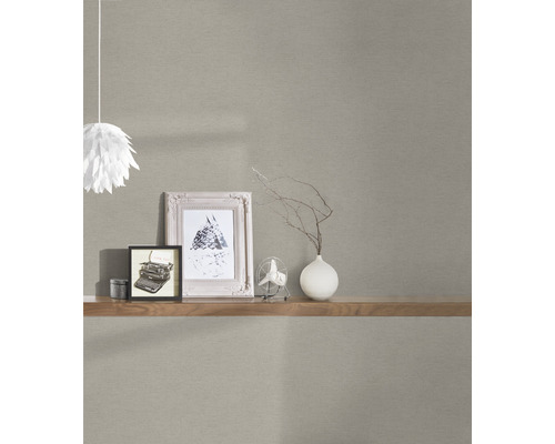 Lichtgekleurd behang met plank, decoraties en lamp in interieur