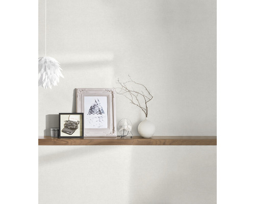 Woonkamer met behang, plank en decoratieve elementen zoals fotolijsten en vaas