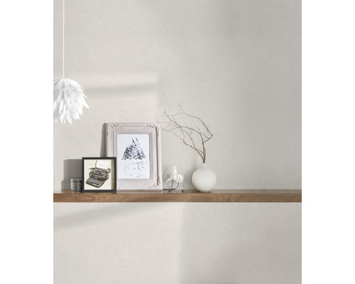 Lichte kamer met patroonbehang, houten plank, decoratieve objecten en hanglamp