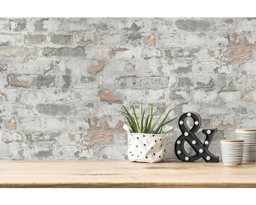 Decoratieve muur met baksteenbehang, potplant en decoratief &-teken op een tafel