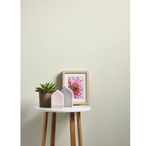 Decoratieve scène met kamerplant, huizen en een foto op een bijzettafel.