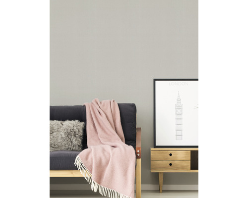 Woonkamer met bank, kussen, deken en dressoir met foto