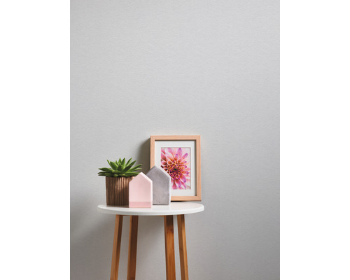 Decoratieve opstelling met potplant, huisfiguren en ingelijste afbeelding op bijzettafel