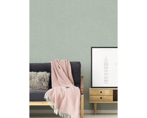 Woonkamer met een bank, een salontafel en een gestructureerd behang