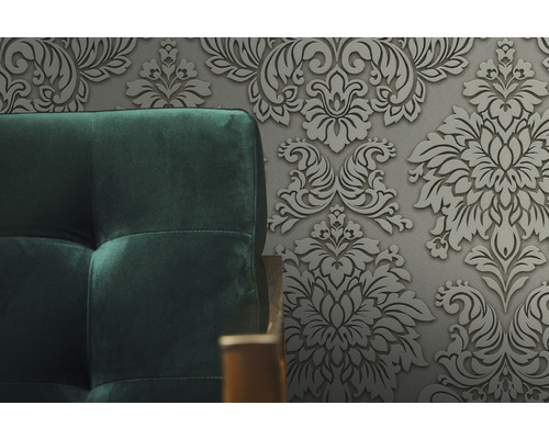 Close-up van een gestoffeerde bank tegen een bloemenbehang