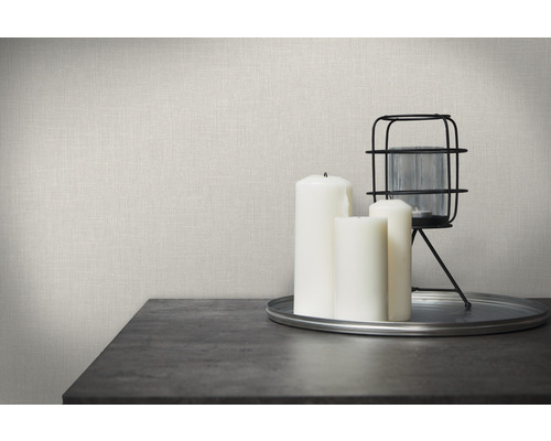 Decoratieve scène met linnen behang, kaarsen en lantaarn op een tafel.