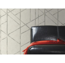 Behang met geometrisch patroon achter een fauteuil