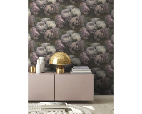 Close-up van een kamer met een behang versierd met bloemmotieven, een kast, een lamp en enkele boeken