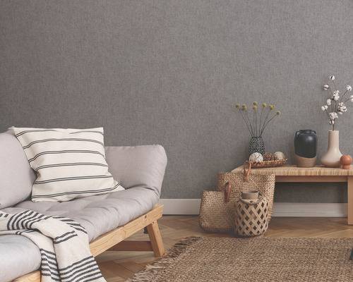 Woonkamer met grijs structuurbehang, bank, tafel en decoratie