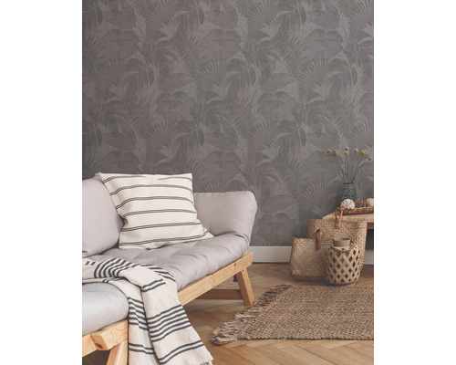 Woonkamer met grijs behang met bladmotief, bank en decoraties