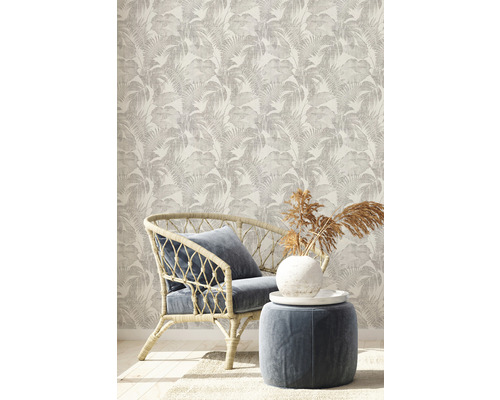 Decoratieve kamer met behang met patroon, rotan stoel en kruk.