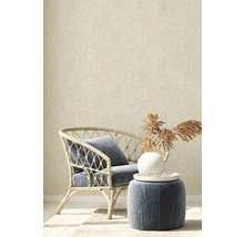 Decoratief interieur met rotan stoel, kussen en bijzettafel voor een beige behang.