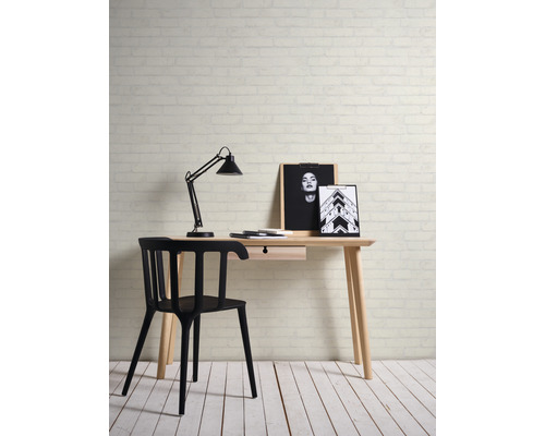 Bureau met lamp, stoel en decoratieve afbeeldingen voor een bakstenen muur