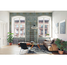 Lichte woonkamer met bank, stoel, vloerkleed en decoratief wandbehang.