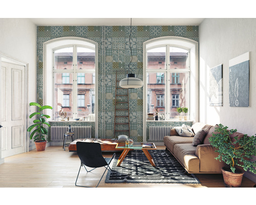 Lichte woonkamer met bank, stoel, vloerkleed en decoratief wandbehang.