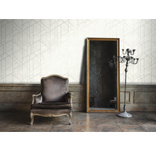 Woonkamer met geometrisch behang, fauteuil, spiegel en kandelaar