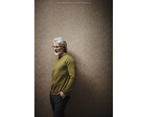 Man met trui voor een muur met behang uit de collectie Metropolitan Stories