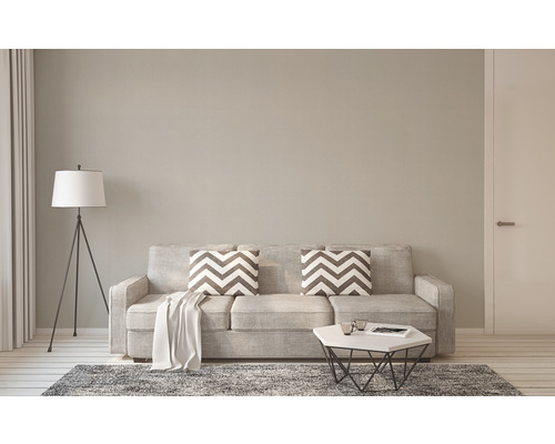 Woonkamer met bank, kussens, vloerkleed, staande lamp en tafel