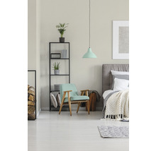Lichte slaapkamer met fauteuil, bed en rek