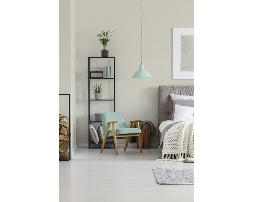 Lichte slaapkamer met fauteuil, bed en rek