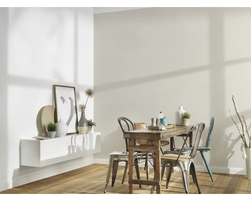 Lichte eetkamer met houten tafel, stoelen en decoratieve elementen aan de muur