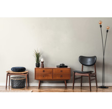 Woonkamer met dressoir, stoel, kruk, vloerlamp en decoratieve objecten
