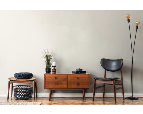 Woonkamer met dressoir, stoel, kruk, vloerlamp en decoratieve objecten