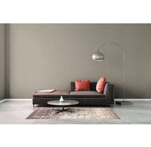 Woonkamer met beige vliesbehang, bank, tafel en vloerlamp