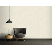 Woonkamer met fauteuil, bijzettafel en hanglamp voor een gestructureerde wand