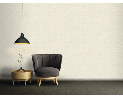 Woonkamer met fauteuil, bijzettafel en hanglamp voor een gestructureerde wand