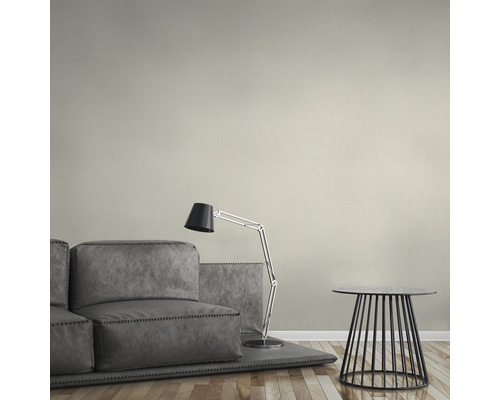 Een woonkamer met een grijze bank, een staande lamp en een kleine bijzettafel.