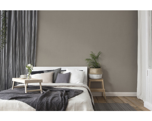 Slaapkamer met bed, nachtkastje, gordijnen en decoraties voor een gezellige sfeer