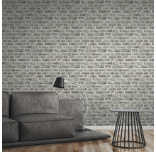 Woonkamer met grijs bakstenen behang, bank, lamp en tafel