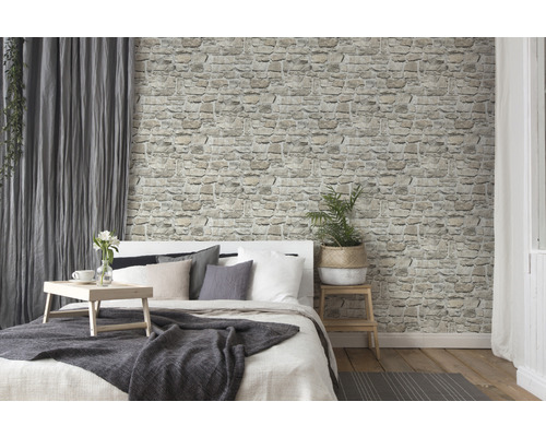 Lichte slaapkamer met stenen muurbehang en bed