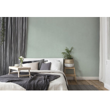 Slaapkamer met bed, nachtkastje, gordijnen en kamerplant voor een gezellige sfeer