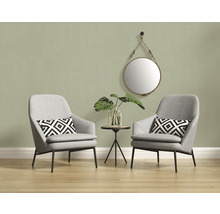 Licht interieur met twee grijze fauteuils, een bijzettafel en een ronde spiegel aan de muur
