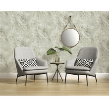 Woonkamer met twee fauteuils, een klein tafeltje, een spiegel en behang met een plantenmotief.