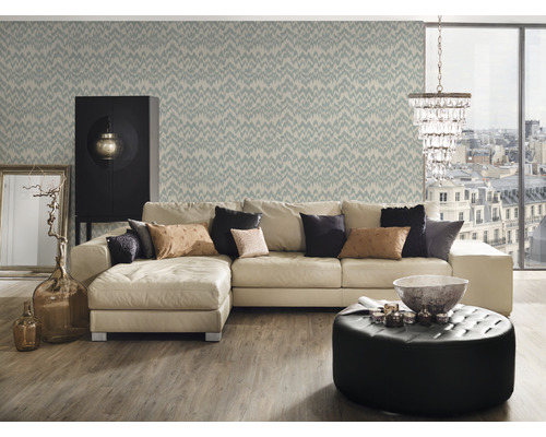 Woonkamer met bank, fauteuil, kast, behang en decoratie