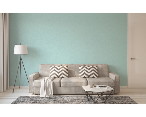 Woonkamer met bank, staande lamp en behang met patroon