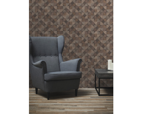 Woonkamer met fauteuil, bijzettafel en behang met geometrisch patroon