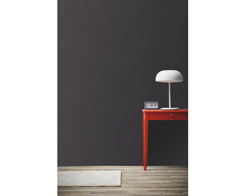 Decoratieve grijze wand met tafel, lamp en vloerkleed voor een moderne woonsfeer.