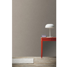 Lichte kamerweergave met bruin behang, rode tafel en witte lamp